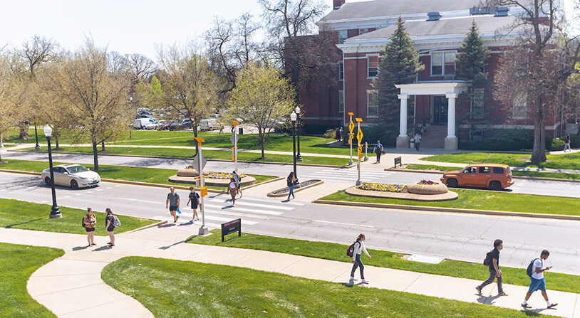 students walking across campus on a sunny day