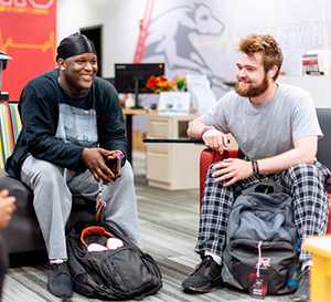 two male students sitting in the welcome center and smiling