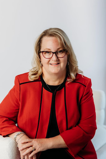 Carissa Newton wearing glasses and a red jacket