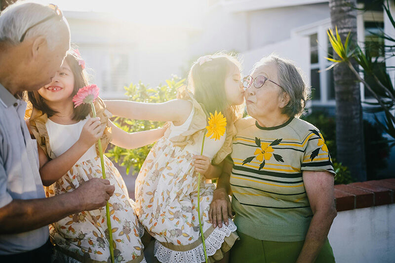 Young girl kissing her Grandmother on the cheek