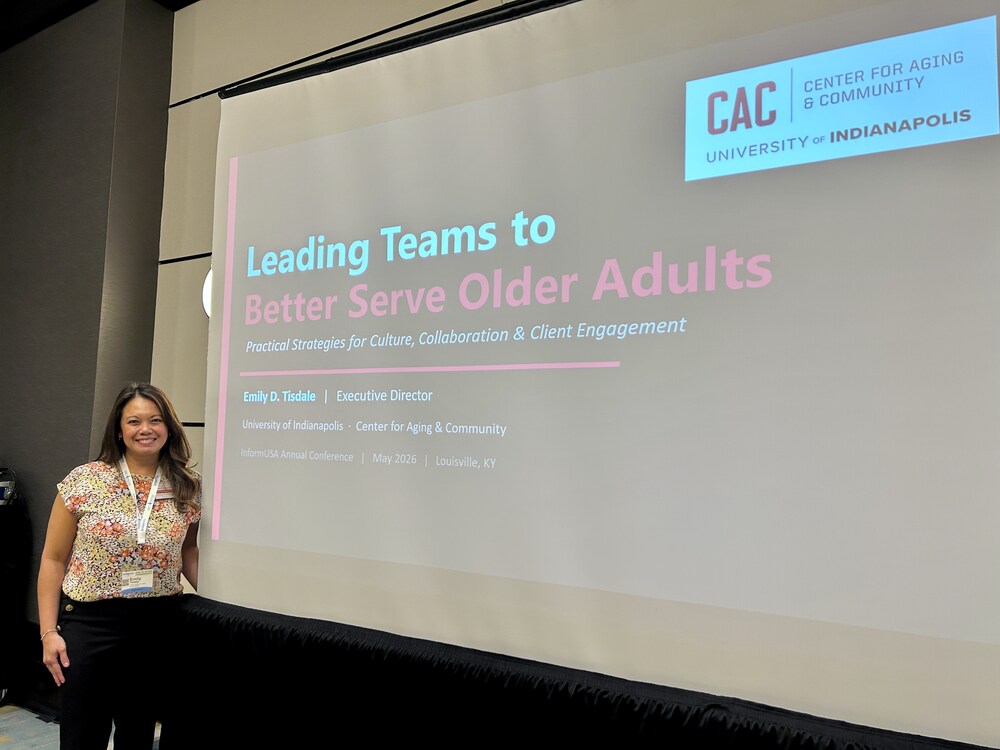 Executive Director Emily D. Tisdale standing in front of her powerpoint presentation