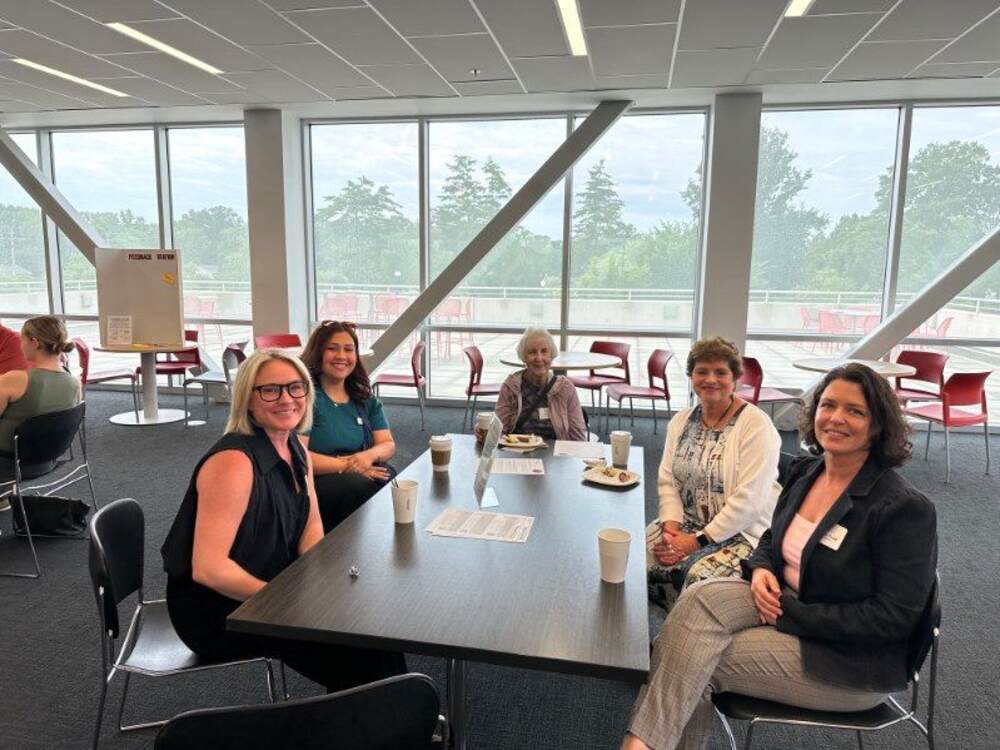 A group of people at a table with coffee and bagels