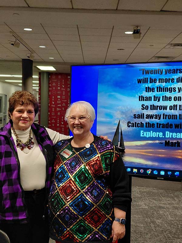 two women standing together and smiling