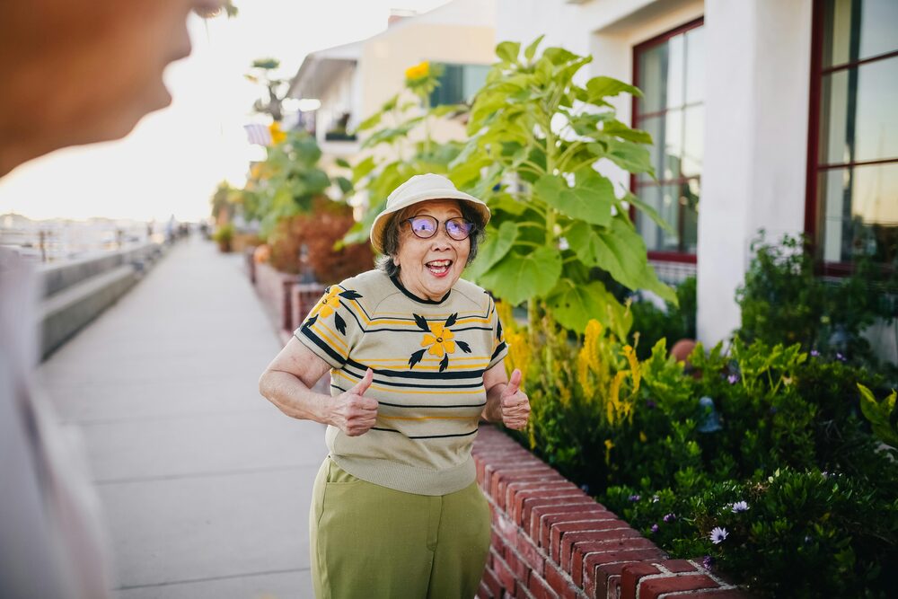 a woman smiling near a garden