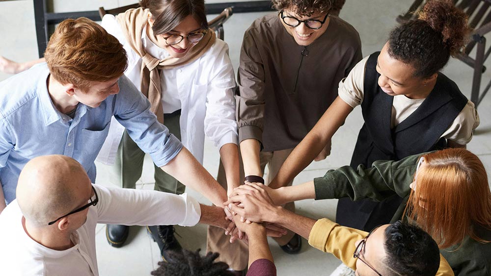 group of people stacking hands together in a circle