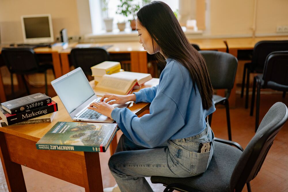 a woman is attending an online class on a laptop