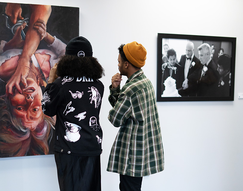 two people looking at a painting