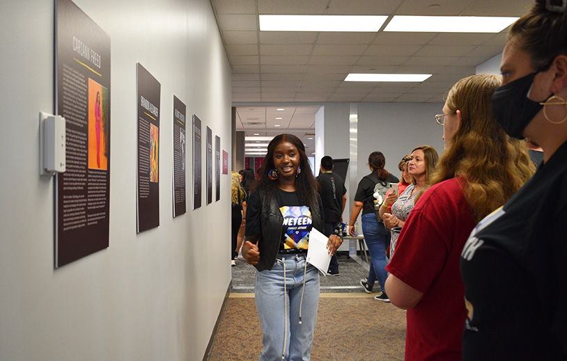 a lady explaining the exhibit to visitors