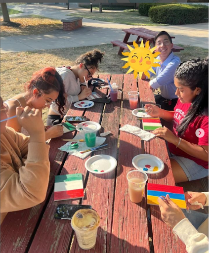 student painting at a picnic table