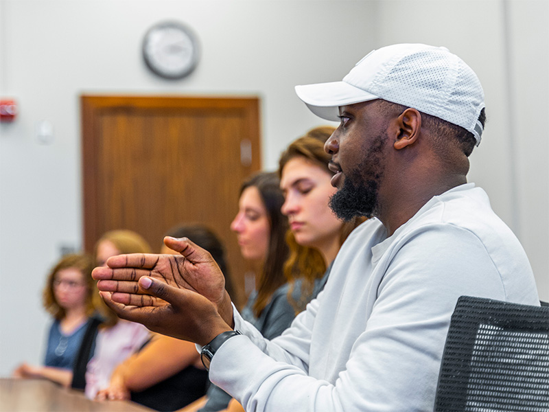 man talking with a group of students