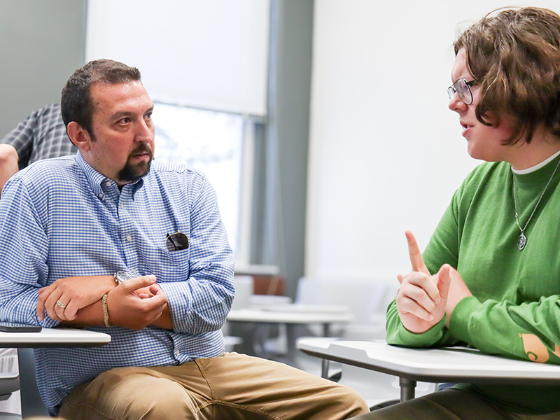 faculty and student engaging in a conversation