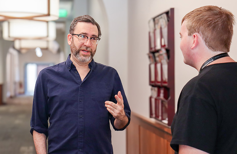professor talking with a student in the hallway