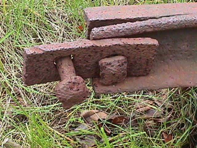 nail hanging off of a metal bar