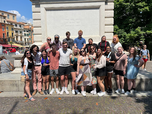 Cordale and UIndy students in front of a statue honoring Italian soldiers.