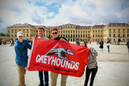 Another shot of UIndy students holding a Greyhounds flag in front of a skyline in Amsterdam.