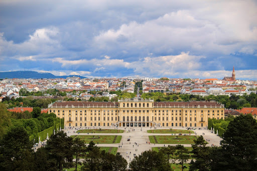 Schonbrun Palace in Vienna, Austria from the top of a hill. The city skyline is behind it.