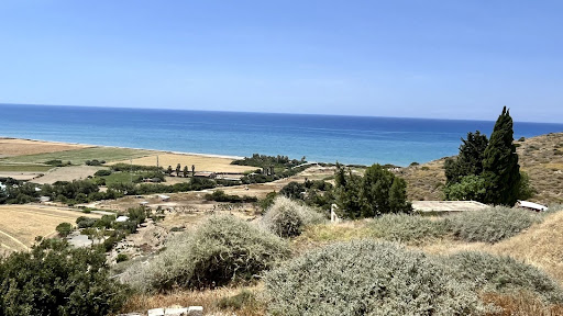 A picture overlooking the countryside and the Mediterranean ocean in Cyprus. There a lots of trees and farmland.
