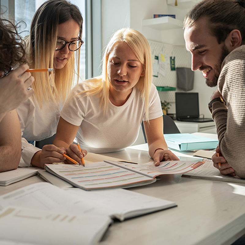 a group of men and women working on a project together