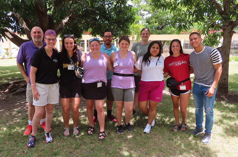 Faculty and students under shade trees during their Dominican Republic trip