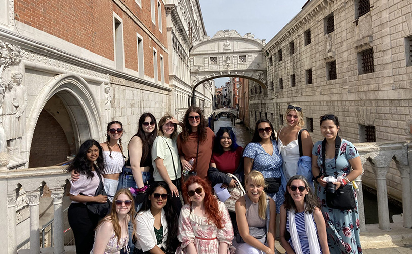 Faculty and students pose near a canal during their Italy Trip