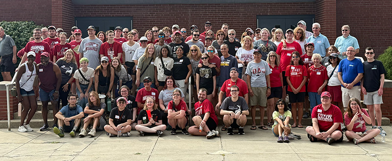 large group of smiling students with staff