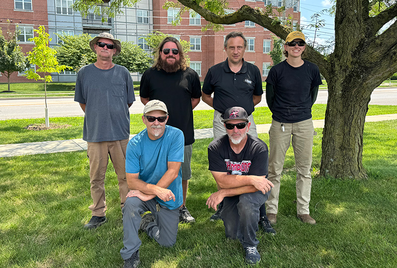 group of 6 men by a tree