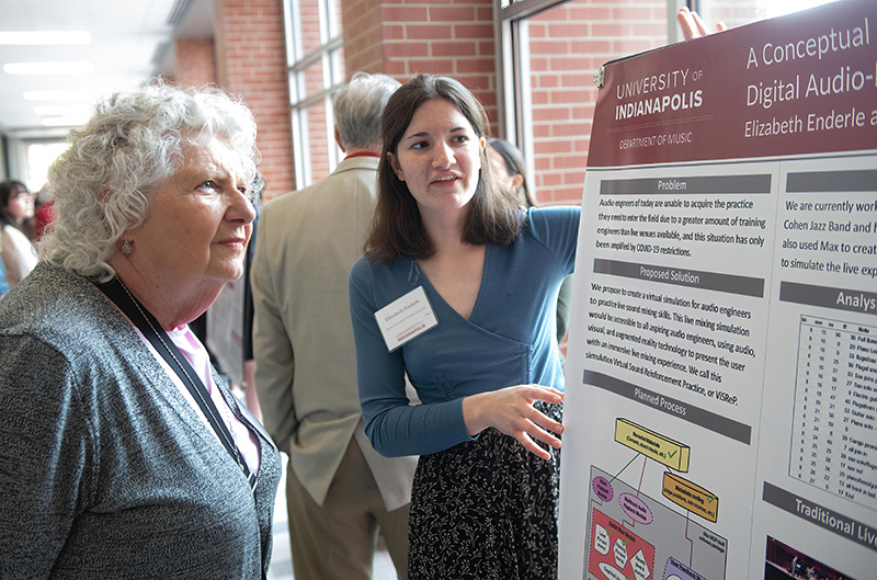 Student explains research project to woman