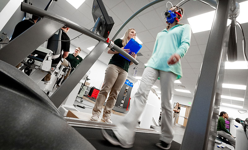 student on treadmill while another student oversees
