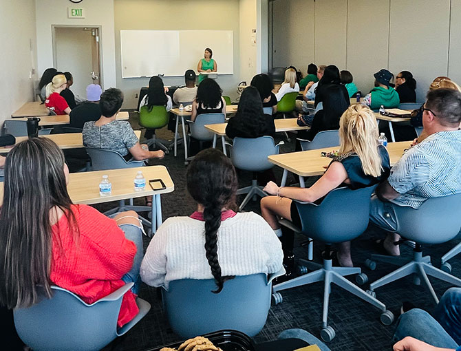 professor at a podium speaking in front of students