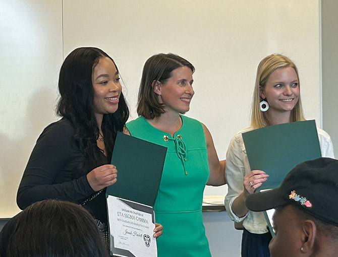 professor presents two students with awards