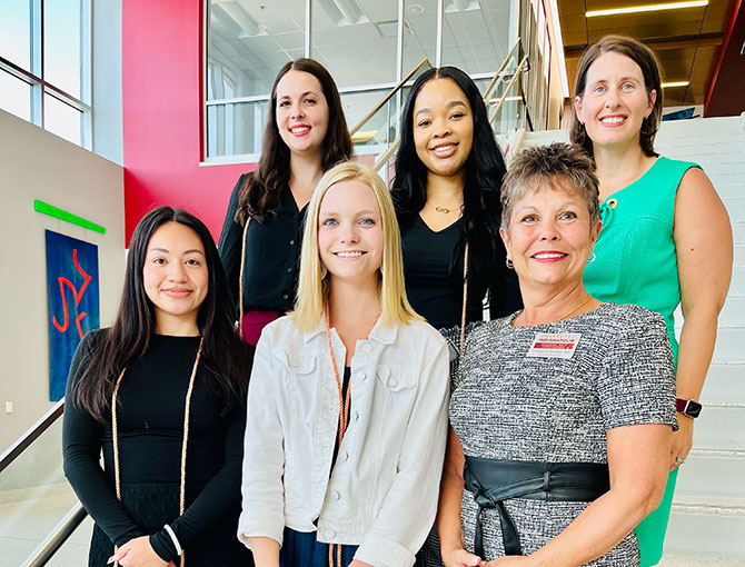 two professors and four students standing on the stairs
