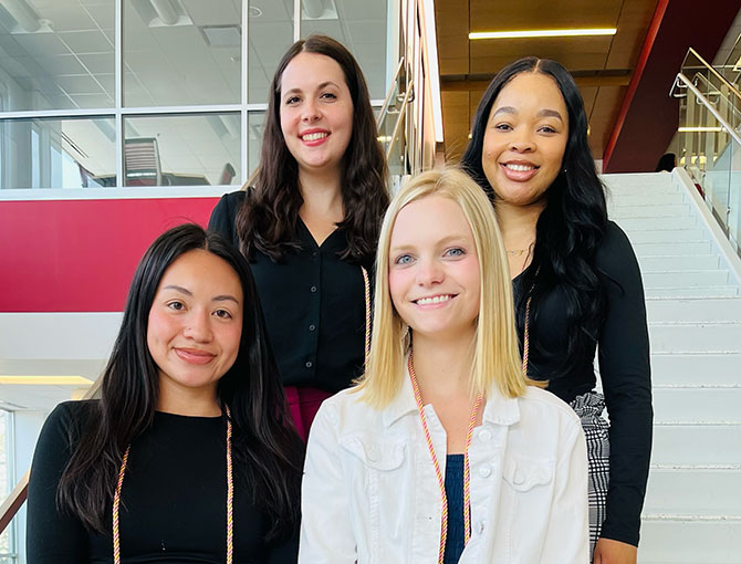 four female students standing on the stairs