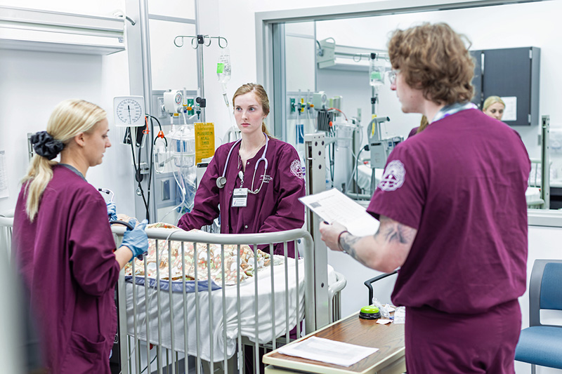 three nursing students in a clinical setting