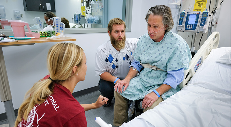 students talking to a patient during a hospital simulation