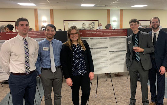 students standing next to a presentation