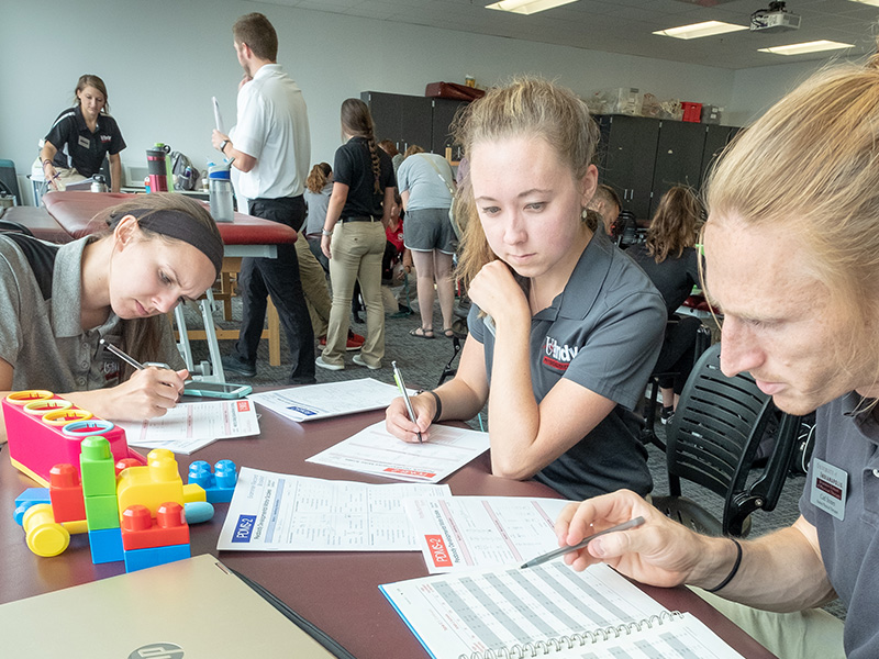 students compare notes and analyze a toddler's physical therapy assessment