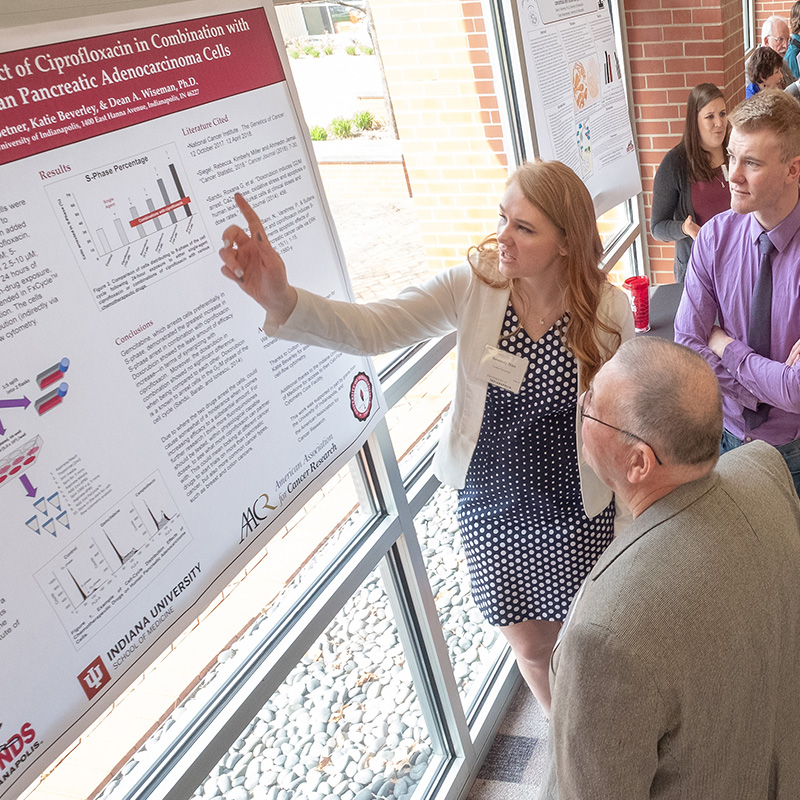 female student giving a poster presentation