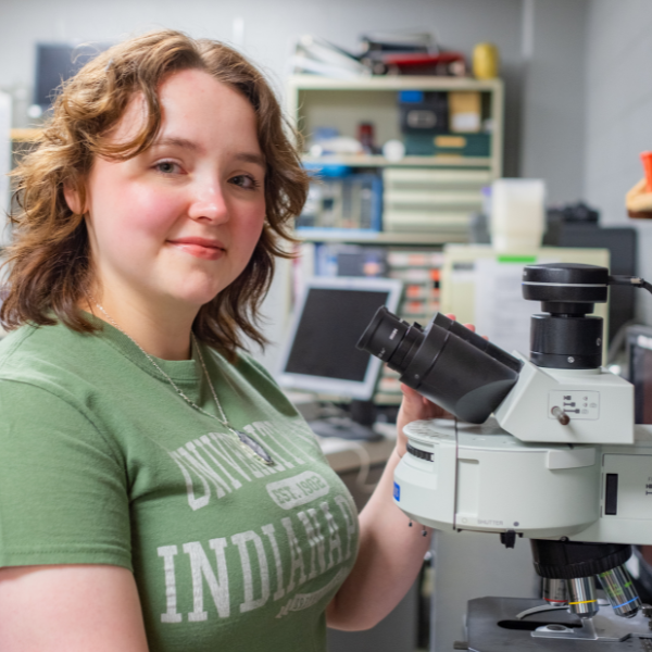 student with microscope in lab