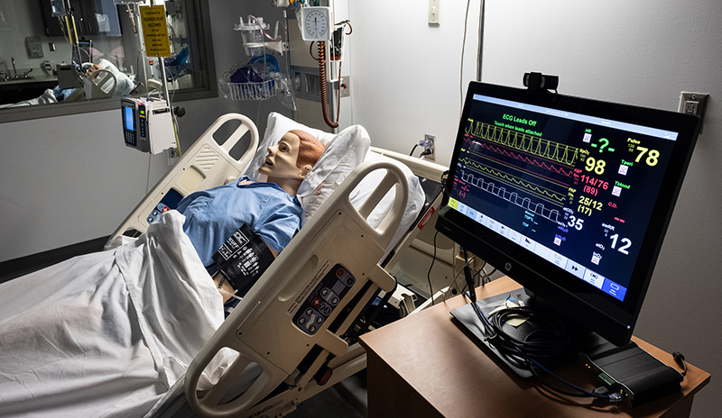 mannequin laying in a hospital bed in the nursing simulation lab