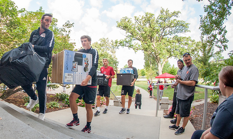 students carrying boxes to move in
