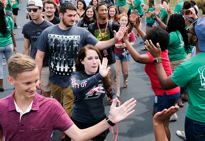 students giving each other high fives during their official welcome to the university