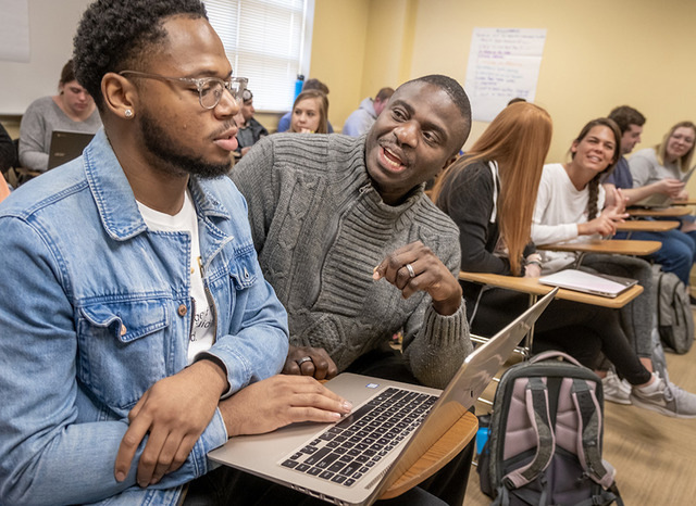 students in class, professor talking directly to a student